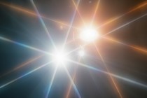 Two shining lights, one blue and one orange, against a black background