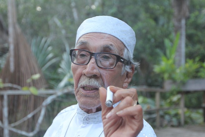 Agustín Rivas Vázquez, a plant medicine specialist in ayahuasca, smokes.