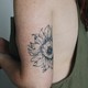 A tattoo of a flower on a young woman's upper arm