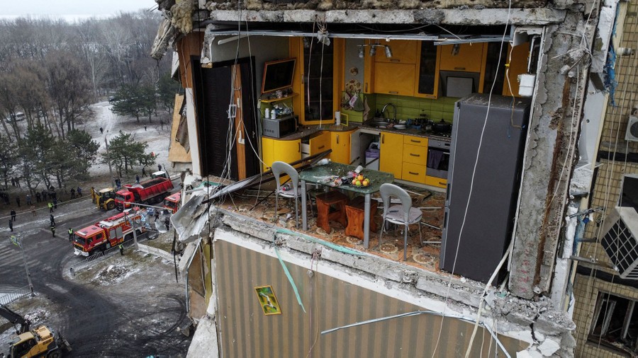 A view of a kitchen in an apartment building, its outside wall blasted away by a missile strike.