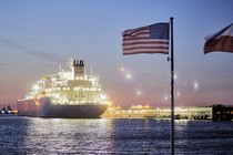 The U.S. and Polish national flags fly in the foreground as the liquefied-natural-gas (LNG) tanker Oak Spirit sits docked with Poland's first import of U.S. LNG at the Gazoport terminal in Świnoujście, Poland, on Thursday, July 25, 2019.