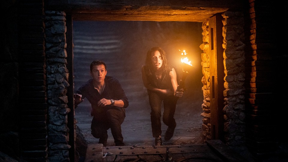 Tom Holland and Sophia Ali crouching at a tunnel entrance in "Uncharted"