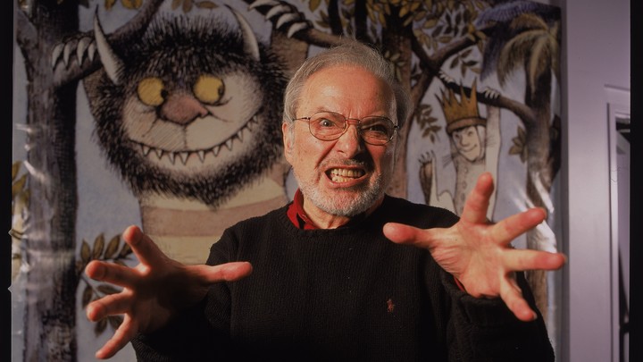 Maurice Sendak makes a gentle spooky gesture in front of his illustrations.