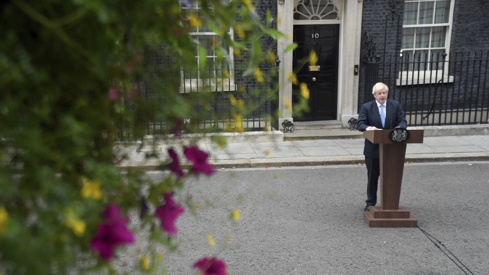 Boris Johnson stands at a lectern on the street outside his 10 Downing Street office.