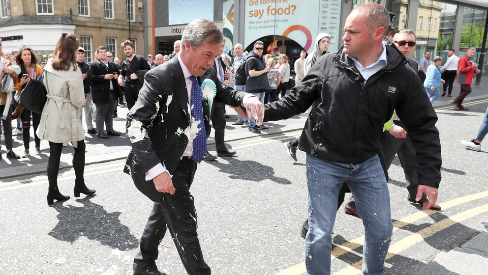Nigel Farage gestures after being hit with a milkshake.