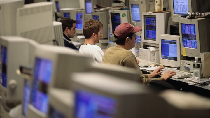 Three young men in a room full of computers