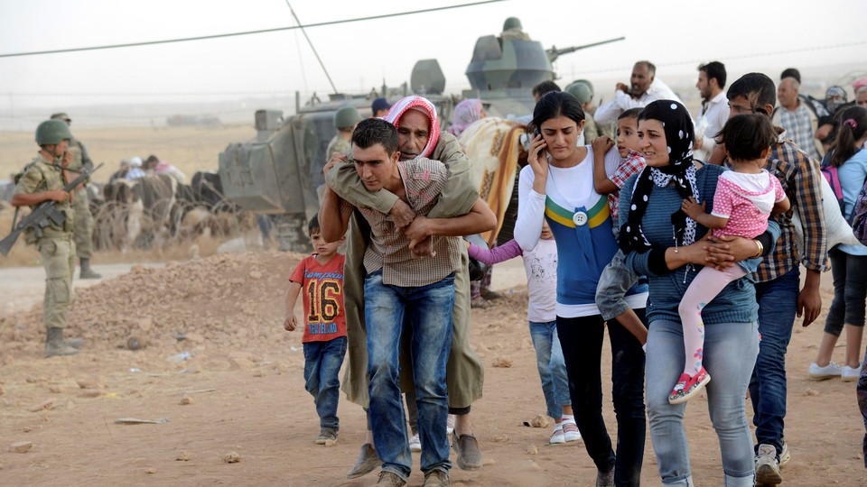 Syrian Kurds cross the border into Turkey, fleeing ISIS, in 2014.