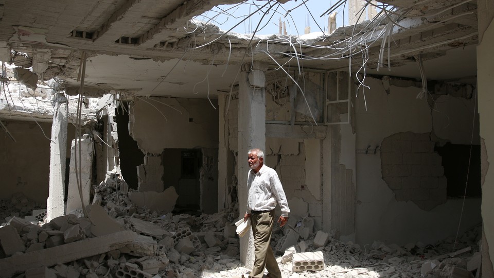 A man walks amid rubble at a damaged site in the province of Daraa, Syria.