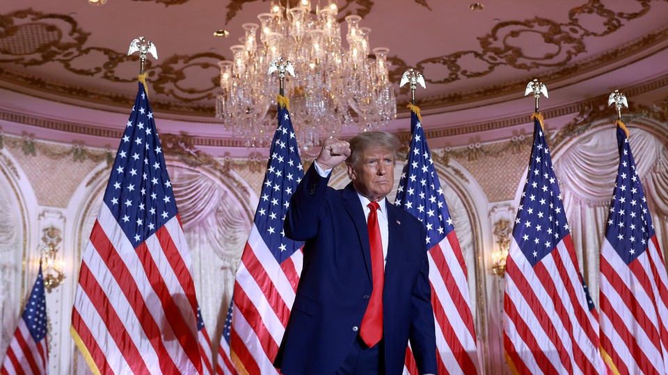 Donald trump raising in his fist in front of American flags