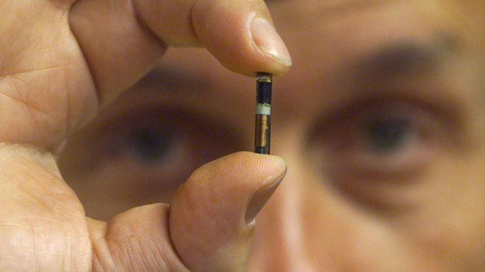 Professor Kevin Warwick holds up an RFID microchip.