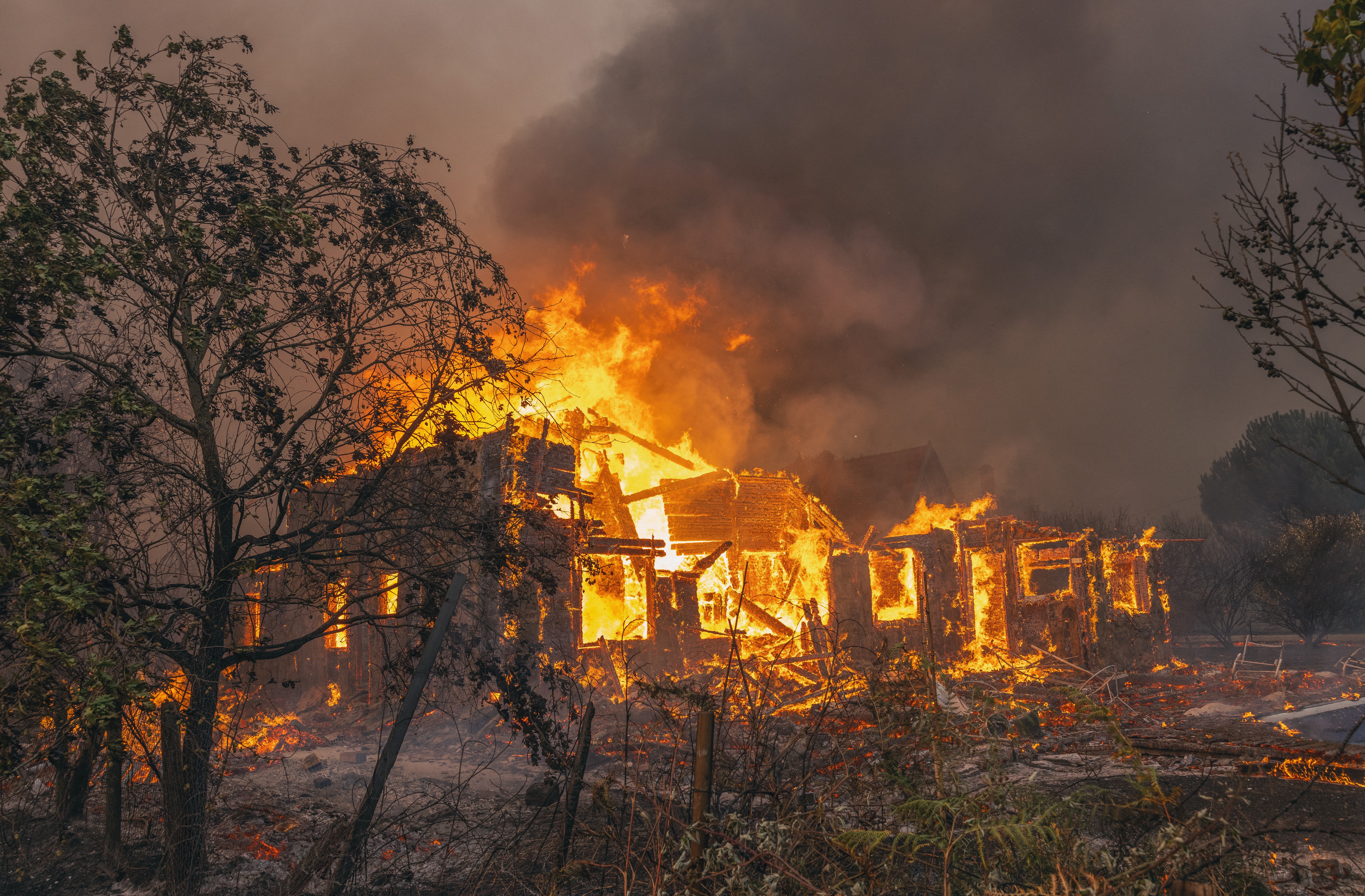 A house goes up in flames during a wildfire.