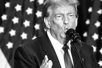 Trump speaking in front of a microphone