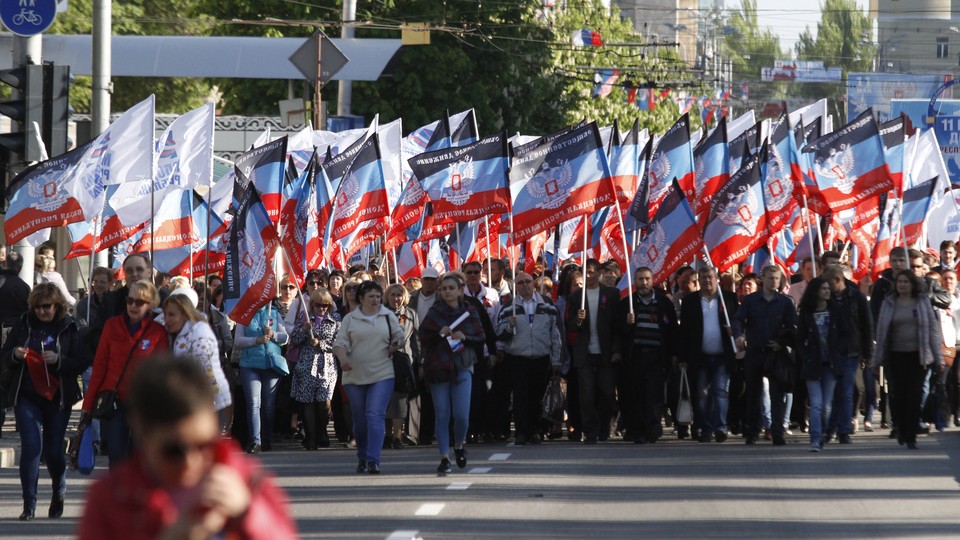 People carry flags of the self-proclaimed Donetsk People's Republic. 
