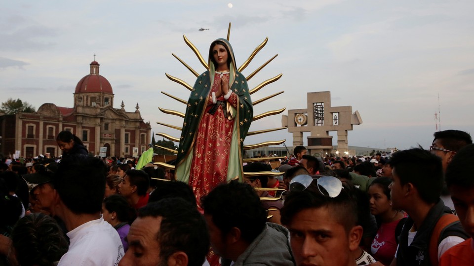 Pilgrims carry a statue of the Virgin of Guadalupe as they arrive at the Basilica of Guadalupe.
