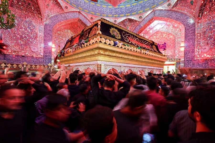 People walk inside a large Muslim shrine.