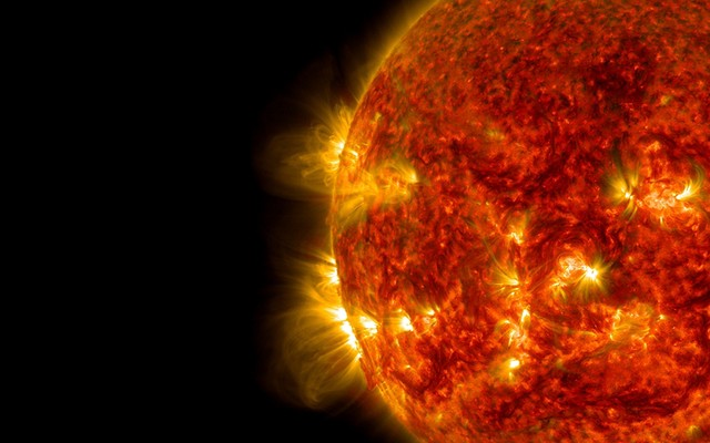 The sun as a fiery red balls spewing particles