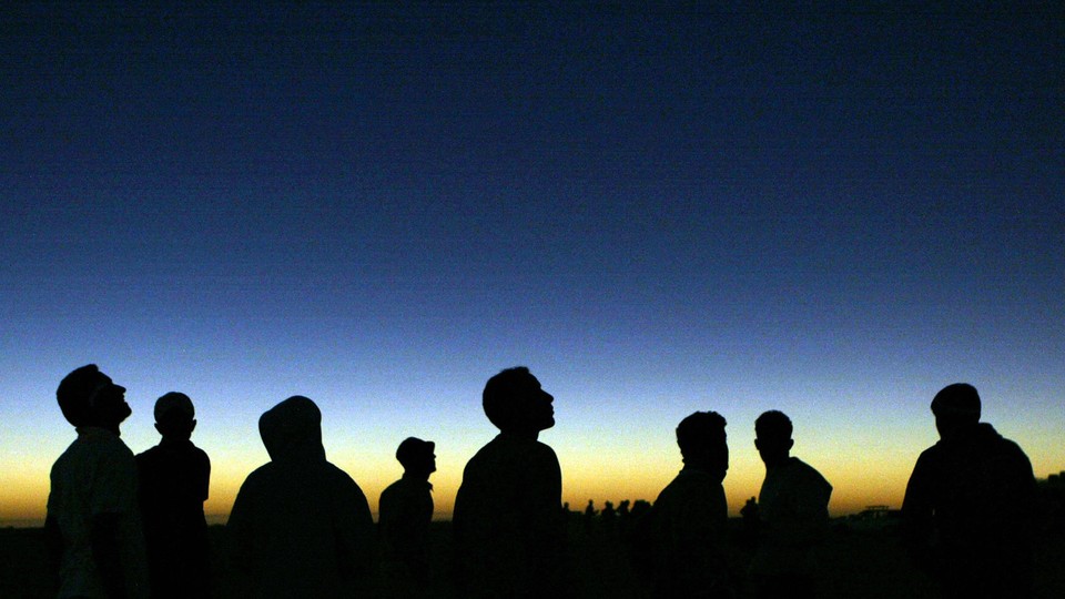 Libyan youths watch the solar eclipse in the desert tourist camp in Galo.