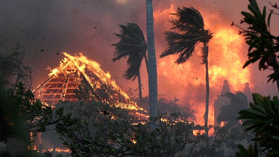Photo of the Lahaina Hongwanji Mission temple on fire, surrounded by palm trees
