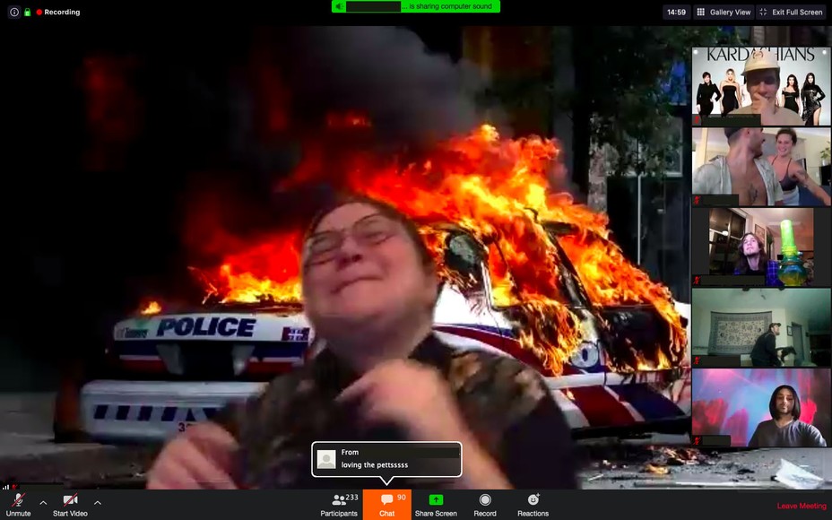 man laughing with zoom background of police car on fire