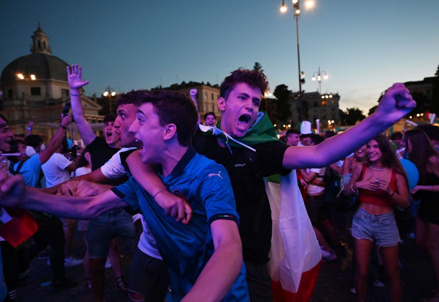 Fans in a square cheer for their team.