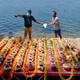 Two men stand in front of 560 urns containing the ashes of Indians who died of COVID-19