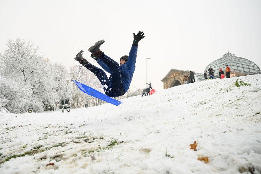 A man tumbles in midair after hitting a ramp while sledding.