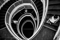 Spiral staircase seen from above, students with backpacks going up and down