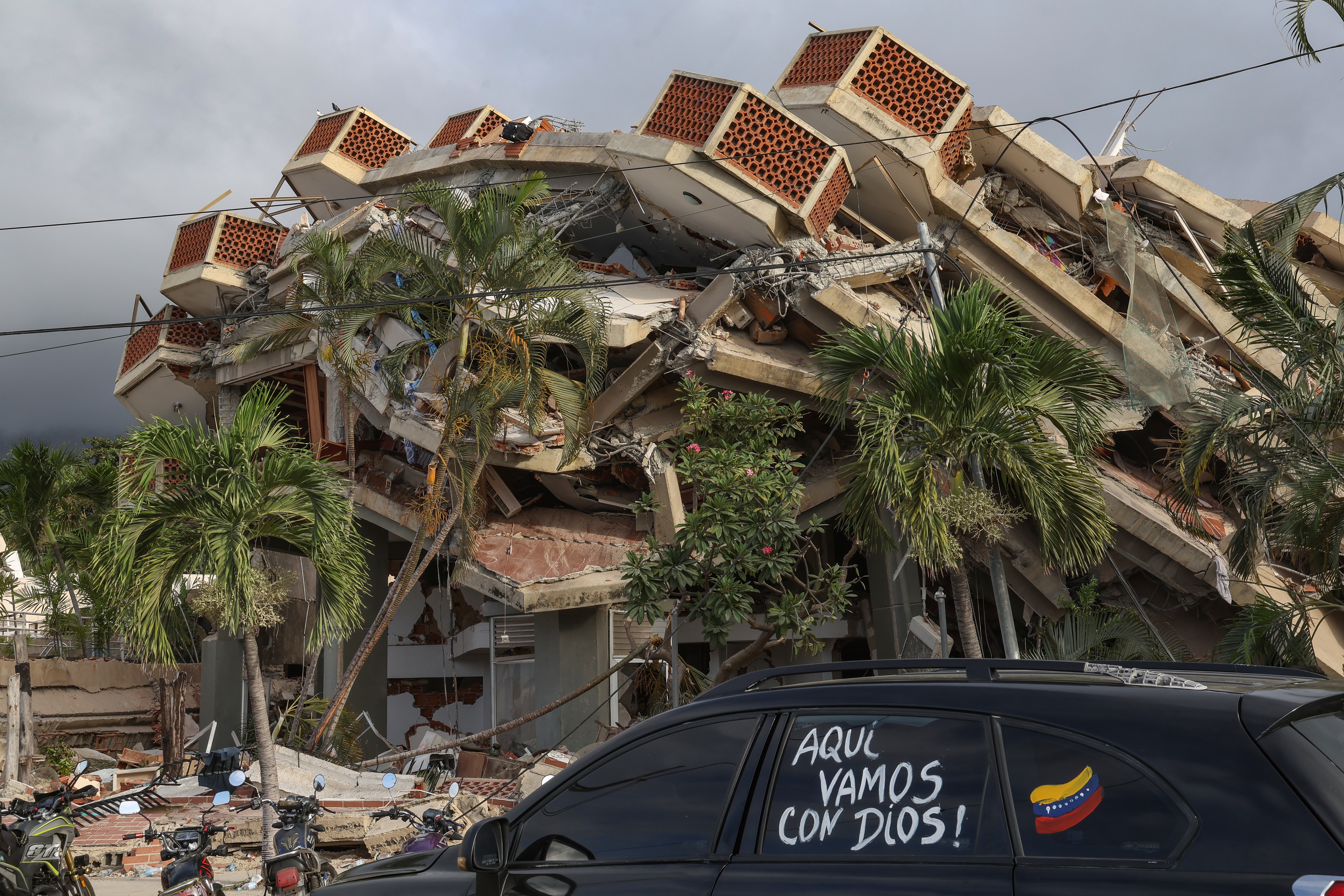 A multi-story building, collapsed on itself after an earthquake.