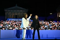 Oprah Winfrey and Kamala Harris hold hands in front of a crowd