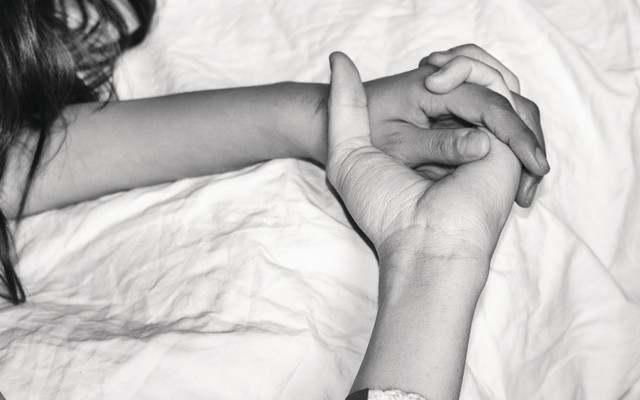 A black-and-white photo of two hands holding