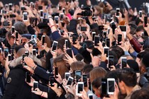 A crowd of people taking photos with smartphones