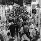 Black and white photograph of people walking through a marketplace in Iran