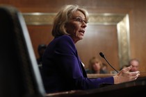 Betsy DeVos sits at a microphone during her hearing.