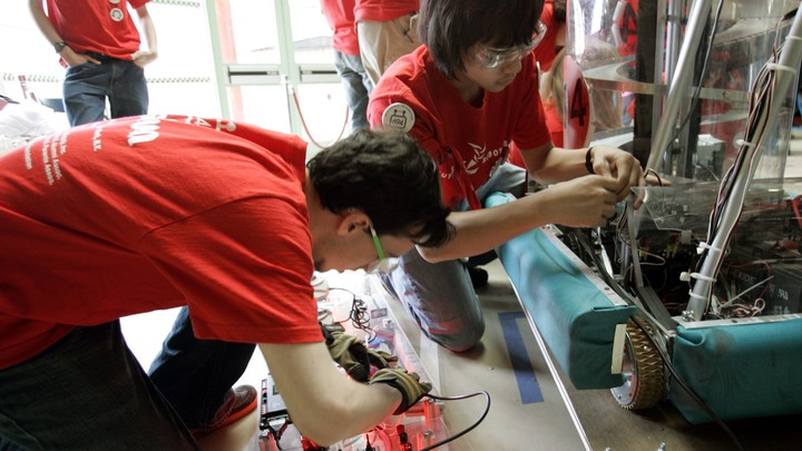 Two students work on a robot.
