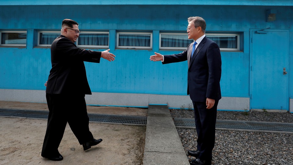 Kim Jong Un and Moon Jae In about to shake hands at the border