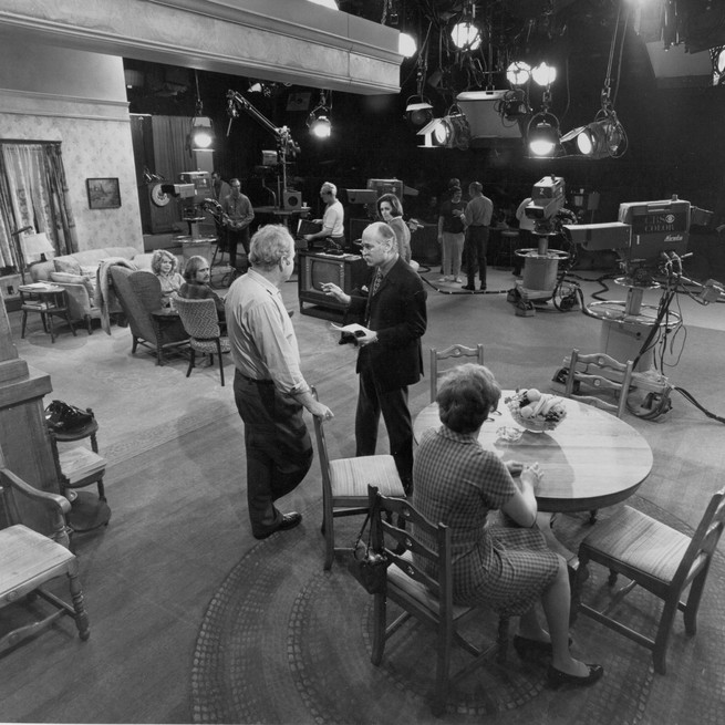 A black-and-white photo shows the set of All in the Family.