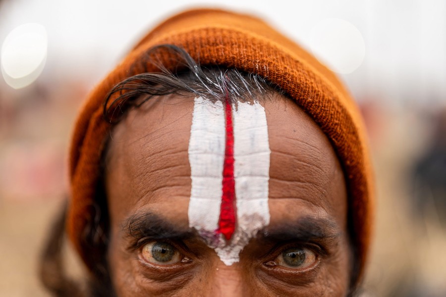 A close view of a person's face, their forehead adorned with a stripe of red and white makeup