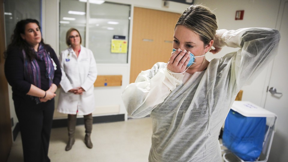 Kaylen Smith demonstrates how to don the protective gear that must be worn when dealing with patients with an infectious disease as Massachusetts General Hospital in Boston prepares for a possible surge in coronavirus patients.