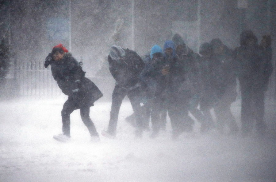 People struggle to walk in the blowing snow during a winter storm in Boston on March 14, 2017.