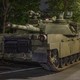 A group of young adults watches a tank roll through the street