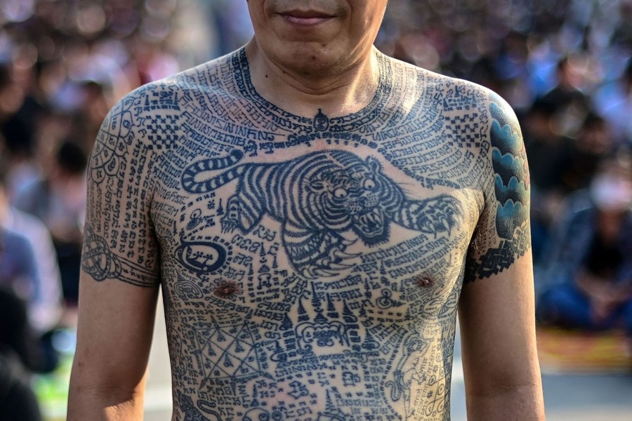 A person's torso and upper arms are covered in tattoos.