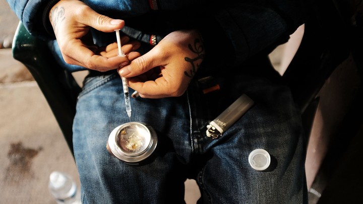 A person prepares to inject an opioid