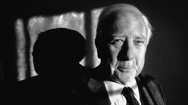 black and white close-up of David McCullough from the shoulders up;  He wears a suit and tie and smiles sweetly.