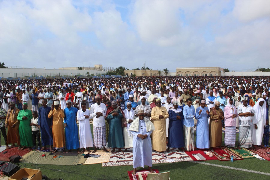 A large group of people gather together in prayer.