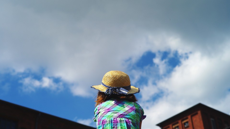 A girl looking at the sky, seen from behind