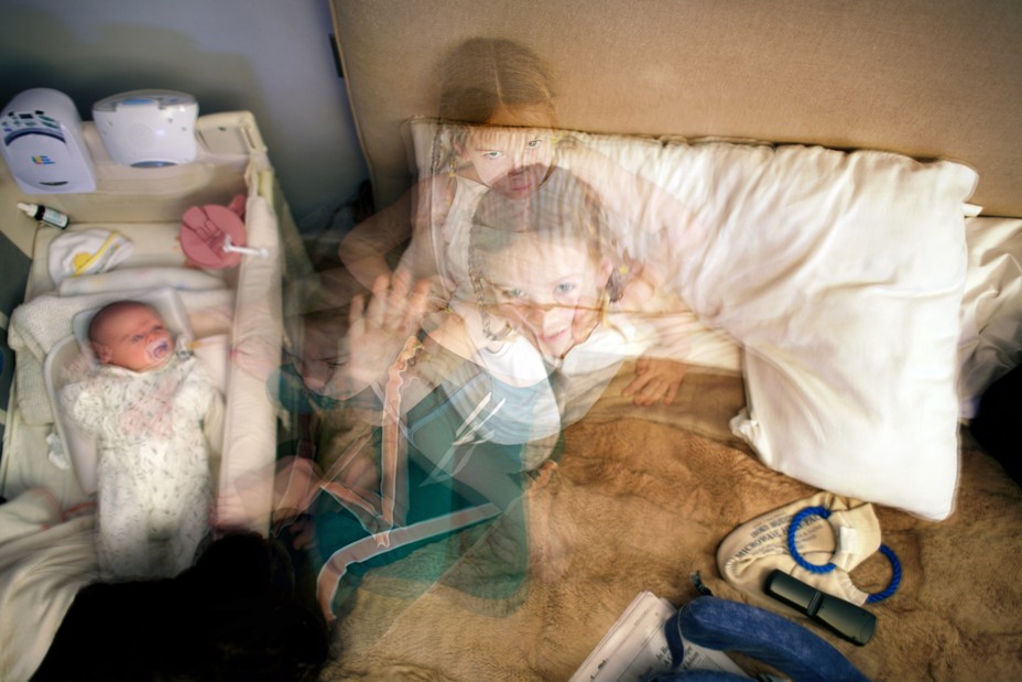 Photo illustration: from overhead, layered photos of young girls on mother's bed next to baby in bassinette