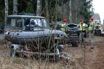 Lithuanian military police stand near military and other vehicles parked at a training range in Pabrade, north of the capital Vilnius, Lithuania on Thursday, March 27, 2025.