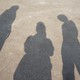 The shadows of three figures on the ground