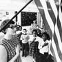 An archival photo of an American classroom saluting the American flag