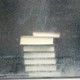 A stack of books seen through a dirty window